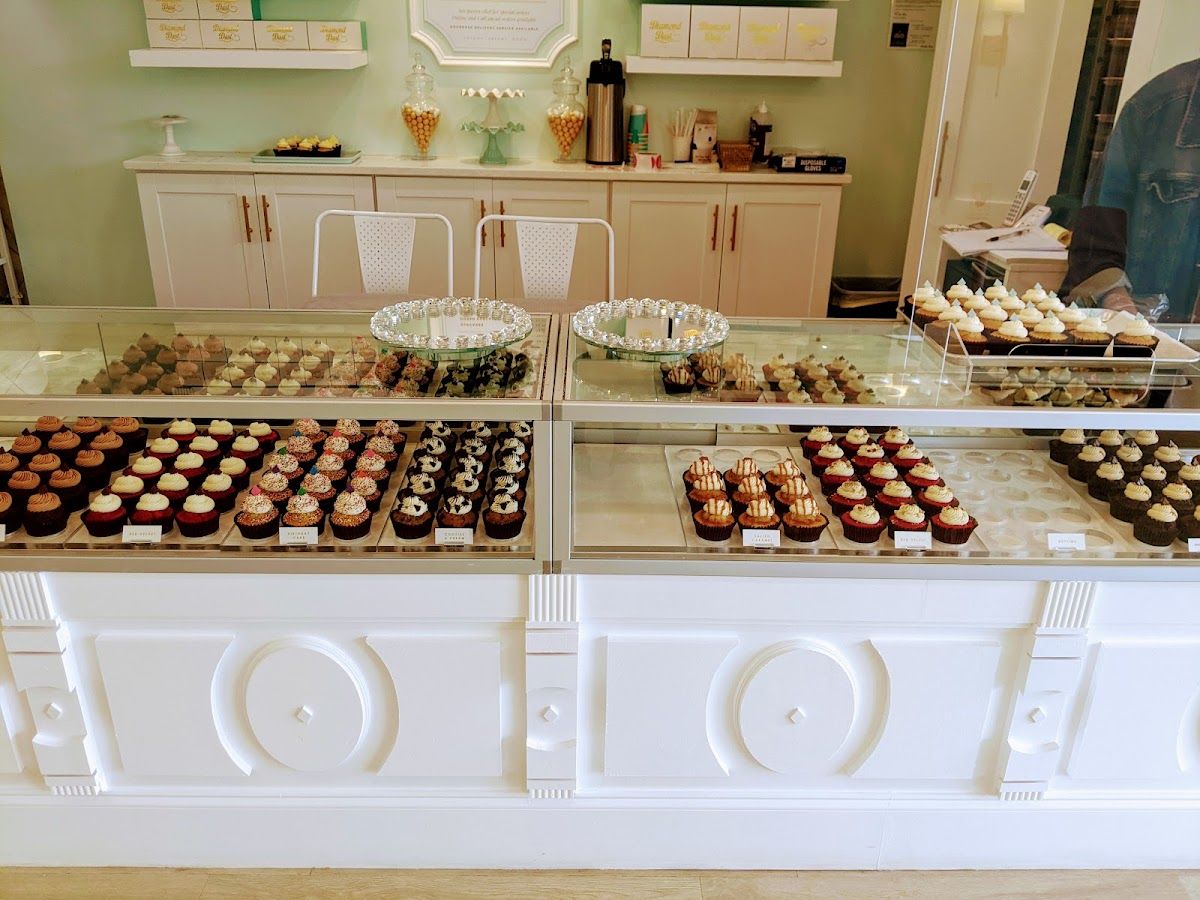 Rows of cupcakes in the bright display case at Diamond Dust