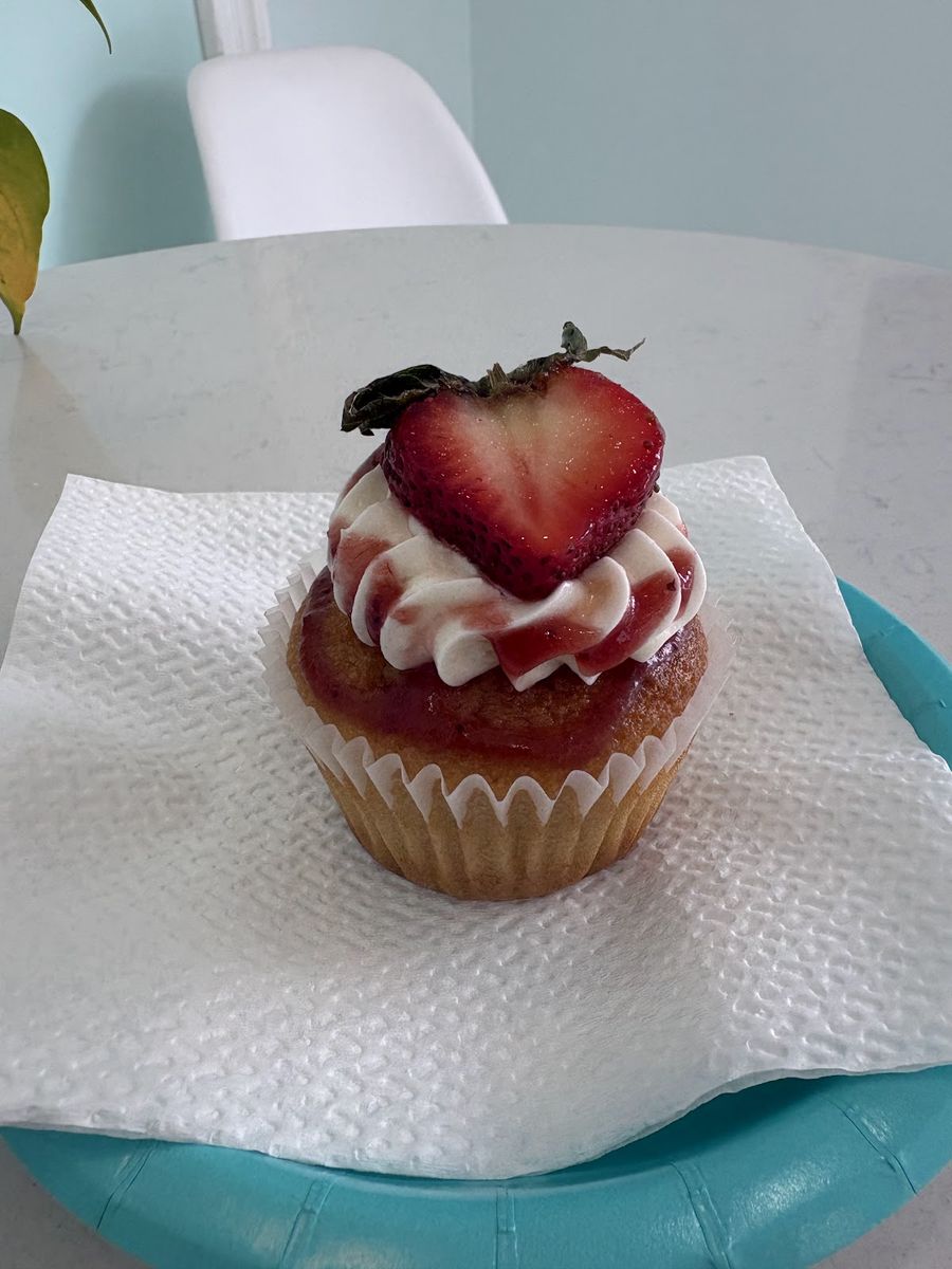 Strawberry cupcake topped with fresh strawberry and swirled buttercream